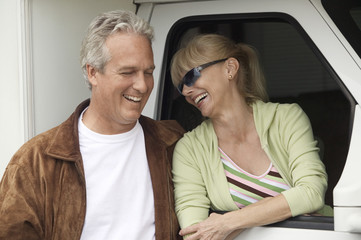 Smiling mature couple next to RV