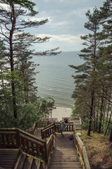 Obraz premium girl sitting on the wooden stairs in park and smiling