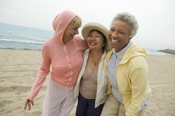 Obraz premium Portret szczęśliwi w średnim wieku żeńscy przyjaciele cieszy się wakacje przy plażą