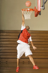 Full length of an African American basketball player missing slam dunk © MDBPIXS