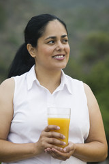 Mid-adult woman holding a glass of orange juice