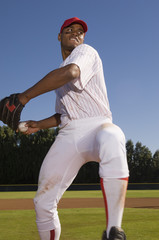 Young baseball pitcher winding up to throw the baseball