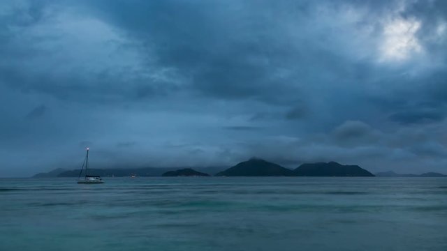 Timelapse sequence of Praslin seen from La Digue, Seychelles at sunset with changing weather and light in 4K
