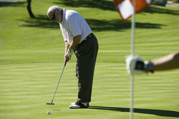 Fototapeta na wymiar Full length of a senior man playing golf at golf course
