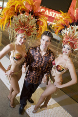 High angle view of middle aged man standing with casino dancers