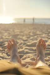Feet closeup on beach on sunbed enjoying sun on sunny summer day.