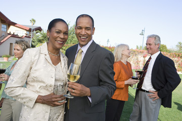 Portrait of an African American couple and friends celebrating with wine at resort