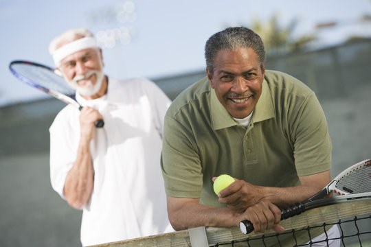 Portrait of senior African American man with friend playing doubles
