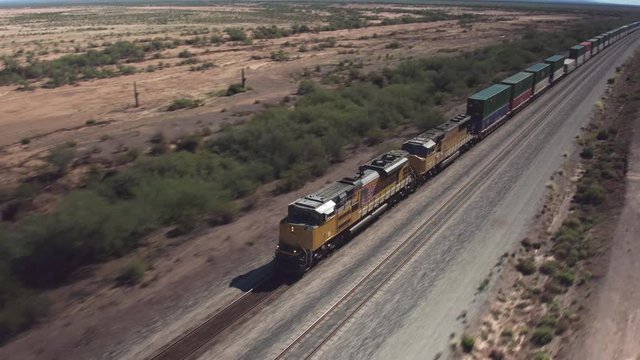 AERIAL: Long container freight train transporting goods across the country