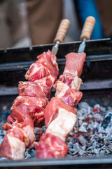 raw meat on skewers cooked on fire