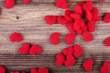 Small red textile hearts on wooden background