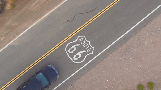 AERIAL: Black car on road trip driving along the historic Route 66 in USA