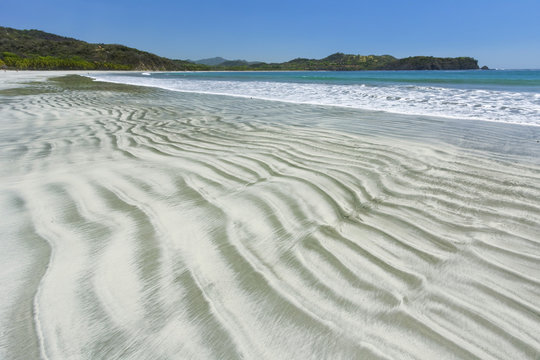 Bands of light sand grains sorted from heavier dark minerals in intertidal zone at Playa Carrillo, Nicoya Peninsula