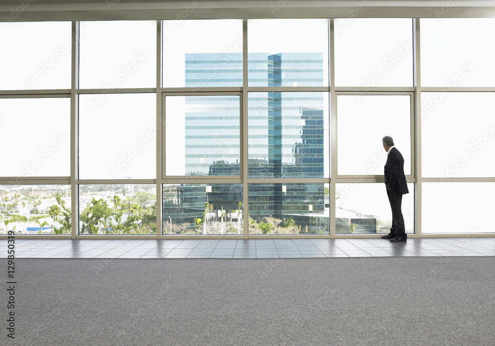 Wall mural full length of businessman looking out of office window