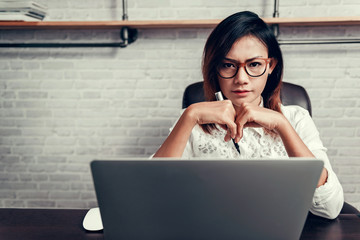 Asian woman with glasses and his pen ready to work. Focus on fac