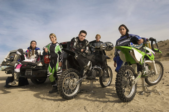 Portrait Of Confident Motocross Racers With Motorcycles And Pickup Truck In Desert