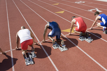 Rear view of multiethnic runners at starting line ready to race