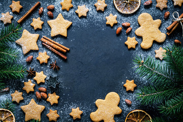 Christmas or New Year background with gingerbread cookies, gingerbread man cookies, stars, spices, cinnamon, fir tree and decorations. Copy space for text