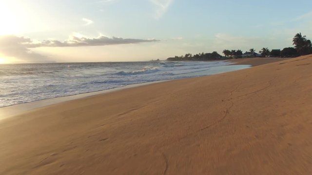 AERIAL: Beautiful ocean waves washing smooth sandy beach along the coastal road