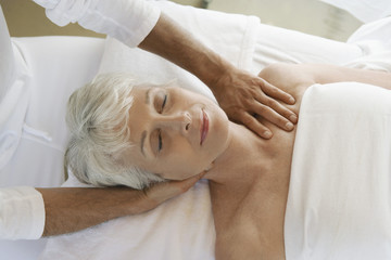 Closeup of a senior woman receiving massage at spa