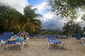 Blonde lying on the sunbed on the beach of Labadee, Haiti. 