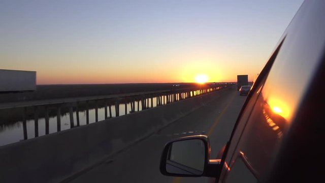 Close up personal car driving on busy highway at beautiful summer sunset