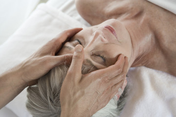 High angle view of a senior woman receiving head massage at spa