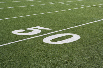 50 yard line on American football field with artificial turf