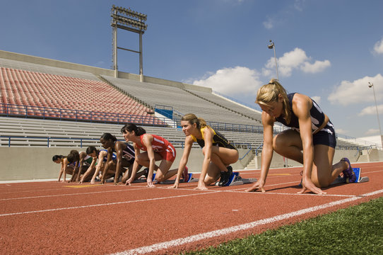 Group Of Runners Preparing For Race At Starting Blocks