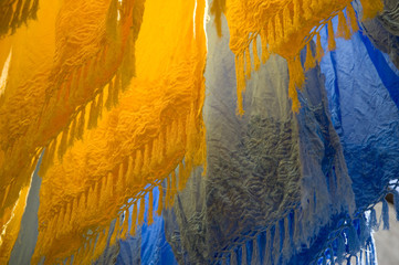 Brightly coloured dyed fabrics hanging to dry in the dyers souk, Marrakech, Morocco