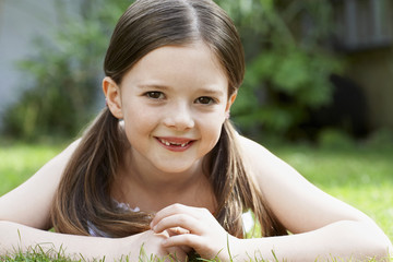 Closeup portrait of smiling young girl lying in grass