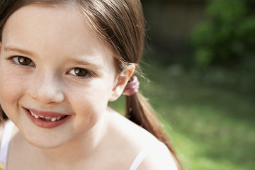 Closeup portrait of cute young girl smiling in park