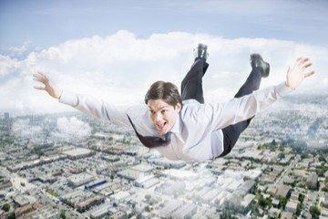 Conceptual image of excited businessman flying in the clouds