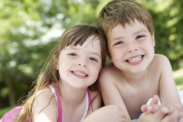 Closeup portrait of a boy and girl lying in the backyard