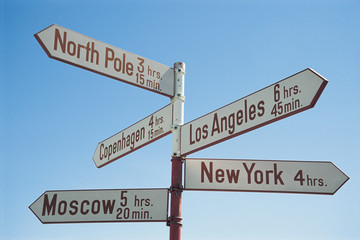 Directions sign post against blue sky