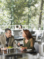 Romantic middle aged couple enjoying meal at restaurant
