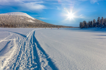 Fototapeta na wymiar Skiing trail in beautiful winter area and skiing men