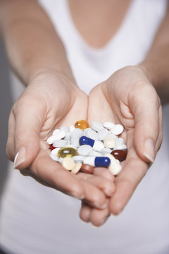 Closeup midsection of a woman holding colorful pills in hands