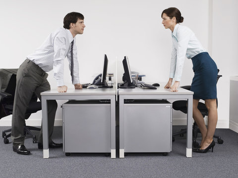 Side View Of A Male And Female Rival Business Colleagues In Office