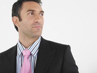 Closeup of a thoughtful businessman looking away against white background