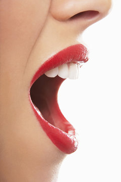 Side view of surprised young woman with red lips on white background