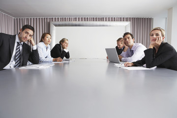 Bored multiethnic business people sitting in conference room - Powered by Adobe
