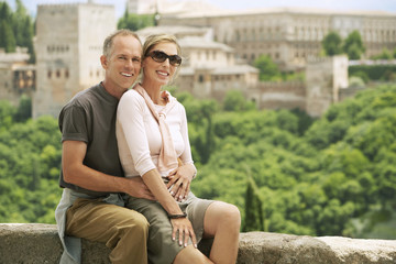 Fototapeta premium Portrait of happy middle aged couple posing on wall overlooking Granada, Spain