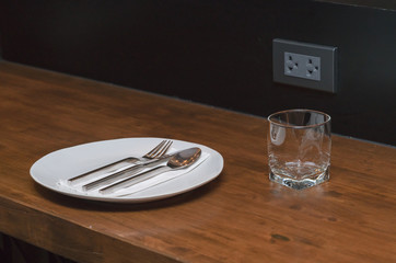 plate, knife and fork on wooden background
