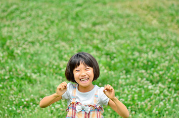 野原でガッツポーズする女の子