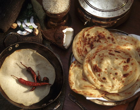 Appam, rice crepes on left, and paratha
