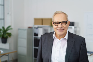älterer geschäftsmann mit brille im büro