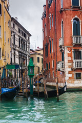 Obraz na płótnie Canvas mooring of gondolas near houses in Venice in rain