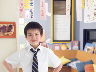 Elementary schoolboy learning to read from hanging paper strip in classroom