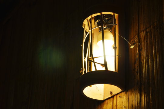 electric lamp hanging on bamboo wall in the night